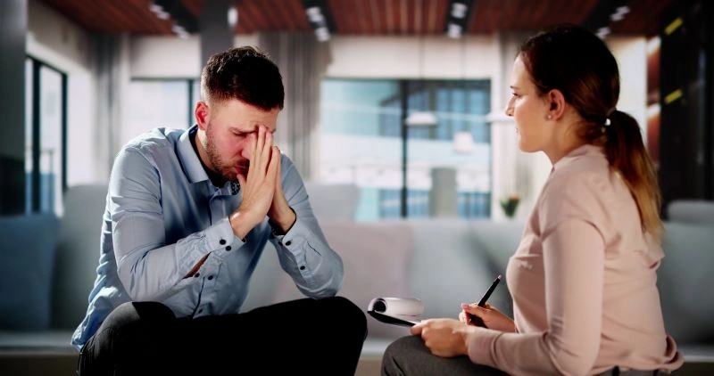 Psychotherapy vs counseling: A man in emotional distress during a therapy session, demonstrating the distinctions between psychotherapy and counseling.