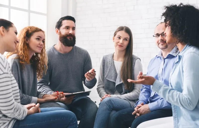 Therapists leading a group session aimed at creating a treatment plan for social anxiety, with participants sharing their experiences.