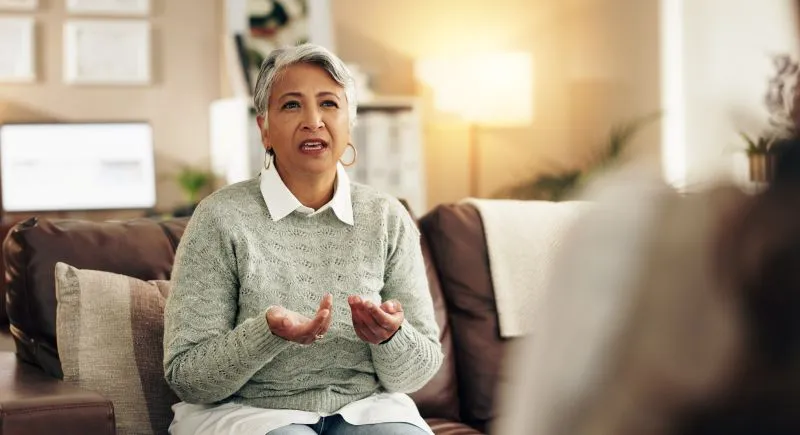 A woman participating in a therapy session discussing her thoughts with a mental health professional, highlighting the benefits of psychiatric telemedicine services.