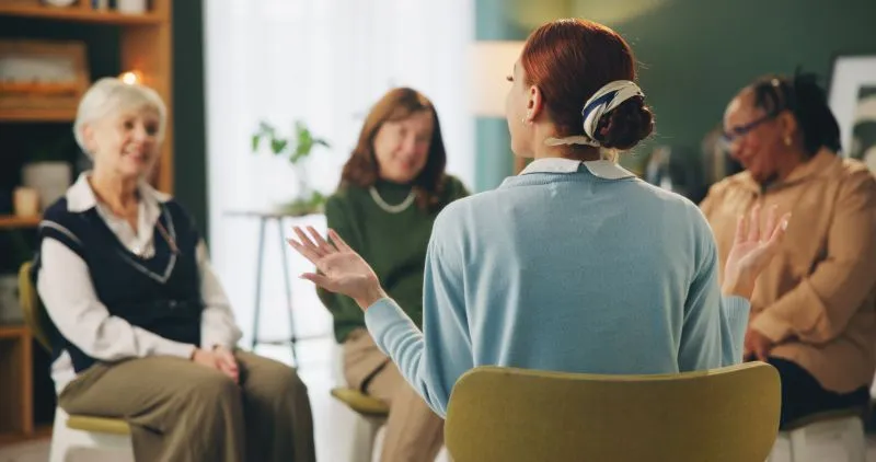 A group therapy session where participants engage in conversation, showcasing telemedicine psychiatric services for mental health support.