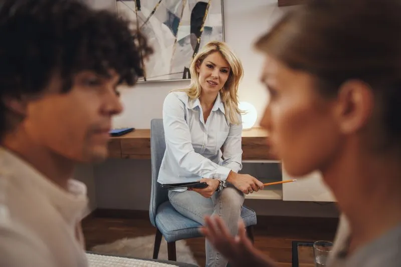 A therapist conducting a counseling session, explaining the difference between therapy and psychiatry to a patient seeking mental health support.
