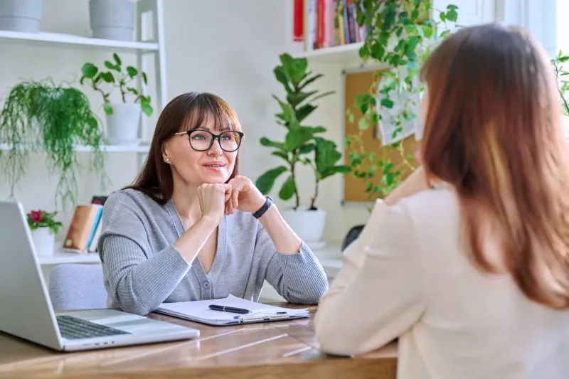 A counselor using a psychological test in a therapy session, exploring the difference between psychiatry and therapy in helping clients with mental health issues.