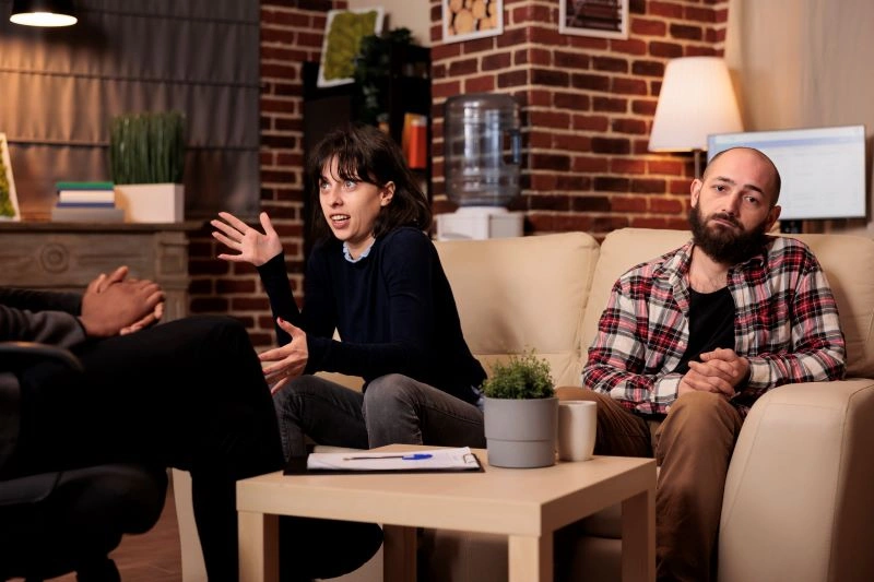 Teletherapy vs in-person: A couple discussing their issues with a therapist in a face-to-face therapy session.