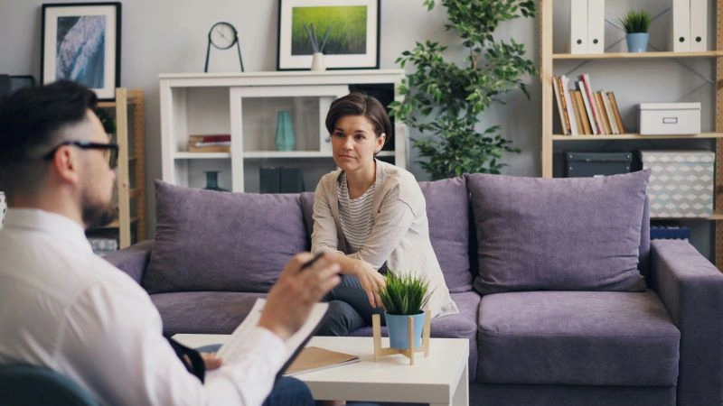 A therapist and client engaged in a discussion, illustrating cognitive therapy's principle of identifying distorted thinking and replacing it with healthier perspectives