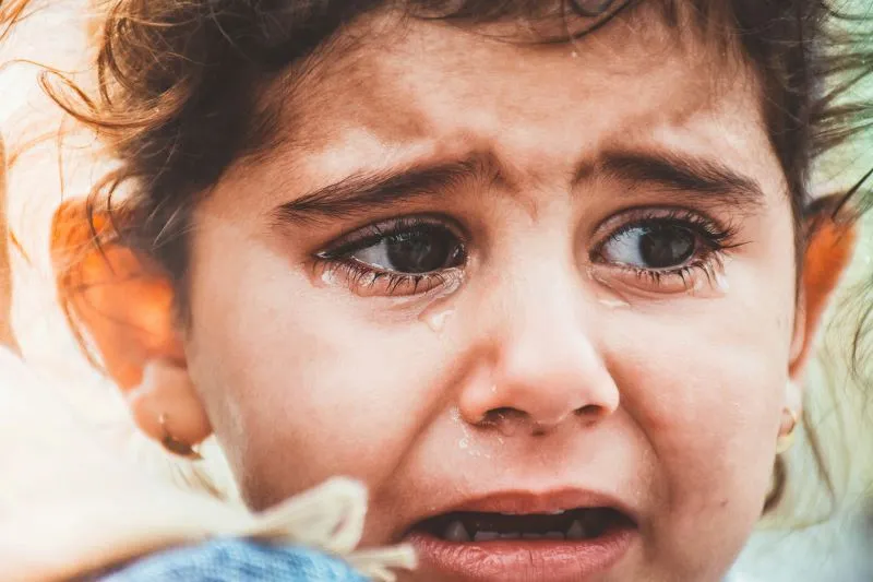 A distressed child with tears, seeking emotional support from an infant mental health specialist to address early emotional challenges