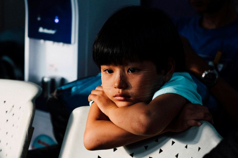 Upset young child sitting alone while awaiting an ADHD assessment for child