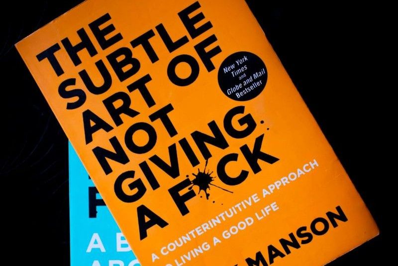 stack of books including The Subtle Art of Not Giving a Fck*, emphasizing practical self-help strategies for mental well-being
