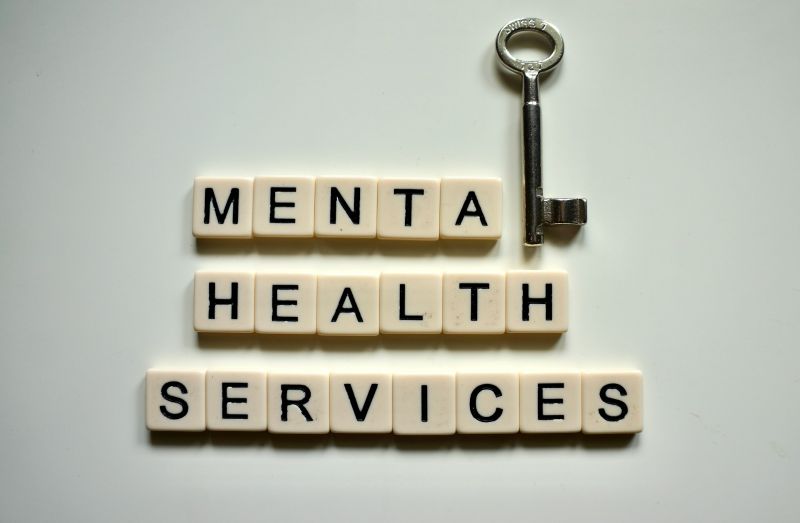 flat lay of tiles spelling “MENTAL HEALTH SERVICES” with a key symbol, representing access to psychiatric care and treatment.