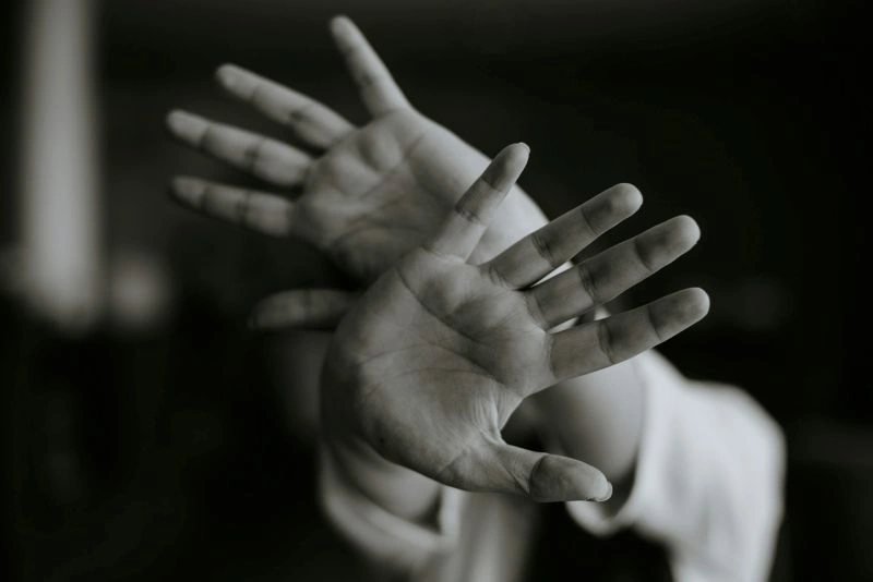 erson raising hands defensively with a blurred effect, symbolizing fear and uncertainty often experienced with health anxiety.