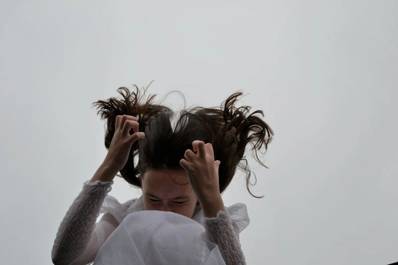 Person appearing overwhelmed while holding their head, illustrating emotional stress related to health anxiety.