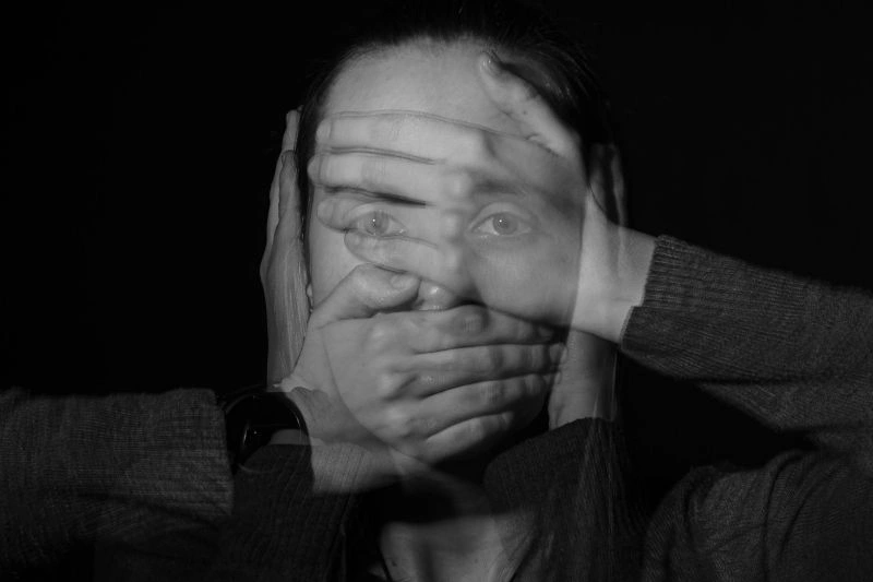 Black and white portrait showing a person overwhelmed by existential anxiety and deep internal thoughts