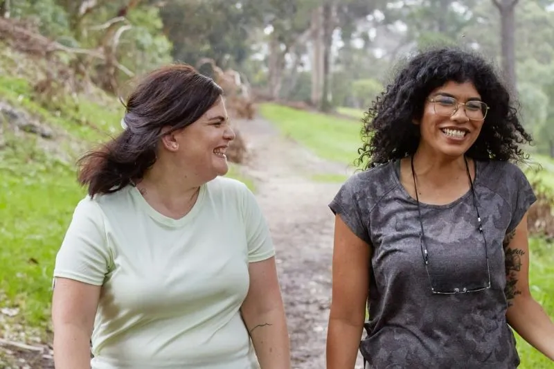 Self awareness and emotional intelligence shown through two women sharing a positive conversation while walking outdoors.