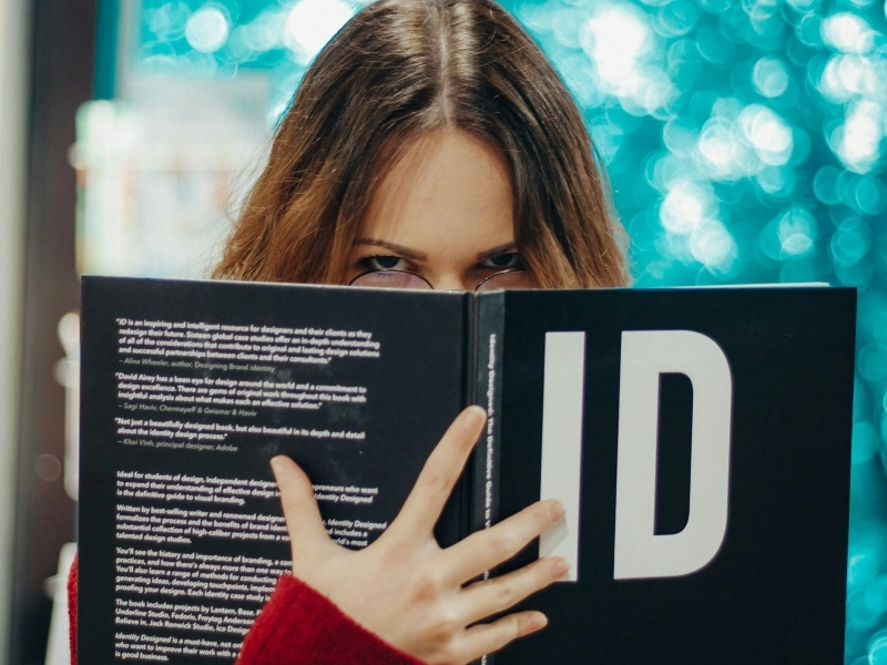 Young woman looking over a book while reading, representing focus and concentration challenges related to high functioning ADHD.