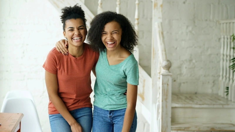 Two smiling women enjoying time together, highlighting social connections and everyday life with high functioning ADHD.