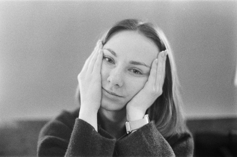 Black-and-white portrait of a thoughtful woman resting her face in her hands, illustrating existential depression.
