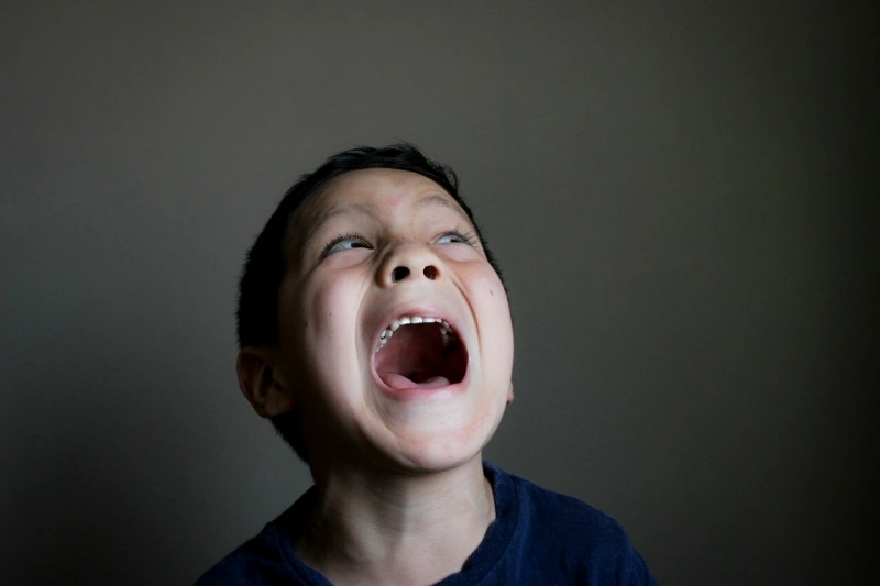 Young boy shouting with an intense facial expression, illustrating emotional regulation challenges discussed in OCD vs ADHD.